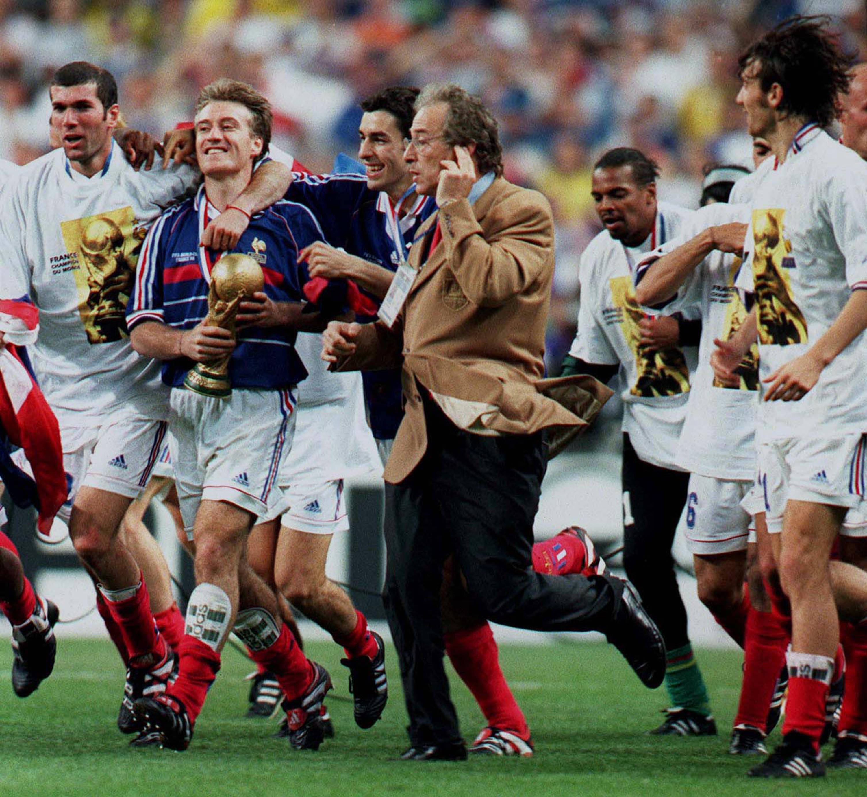 Zidane, Deschamps, and Pires celebrate with the World Cup trophy after France's 1998 victory.